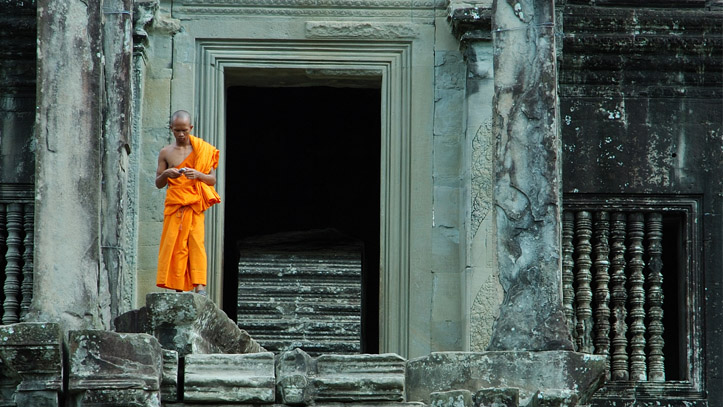 Un moine visitant Angkor Wat